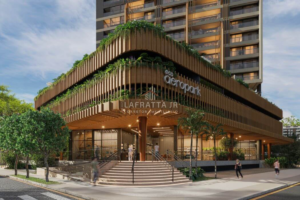 Fachada comercial e residencial do Eco Aeropark em João Pessoa, destacando arquitetura biofílica com brises de madeira, vegetação integrada nos pavimentos e escadaria curva de acesso ao lobby.